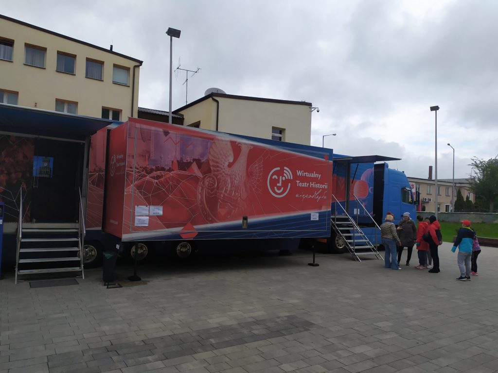 samochód Wirtualnego Teatru Historii na tle budynku
