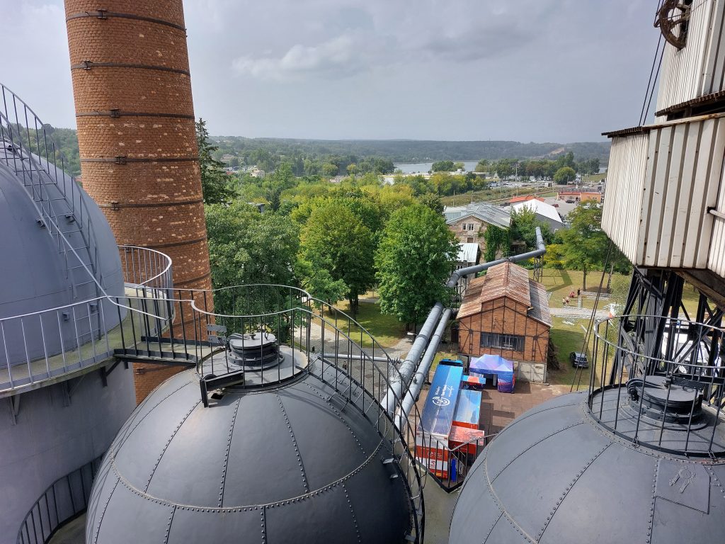 widok na samochód wirtualnego teatru historii niepodległa z góry, na pierwszym planie wieże muzeum techniki