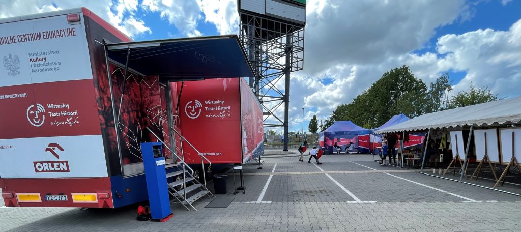 samochód Wirtualnego Teatru Historii na tle parkingu