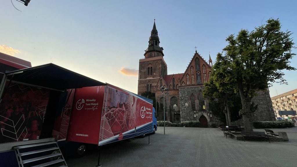 samochód Wirtualnego Teatru Historii na placu przed kościołem