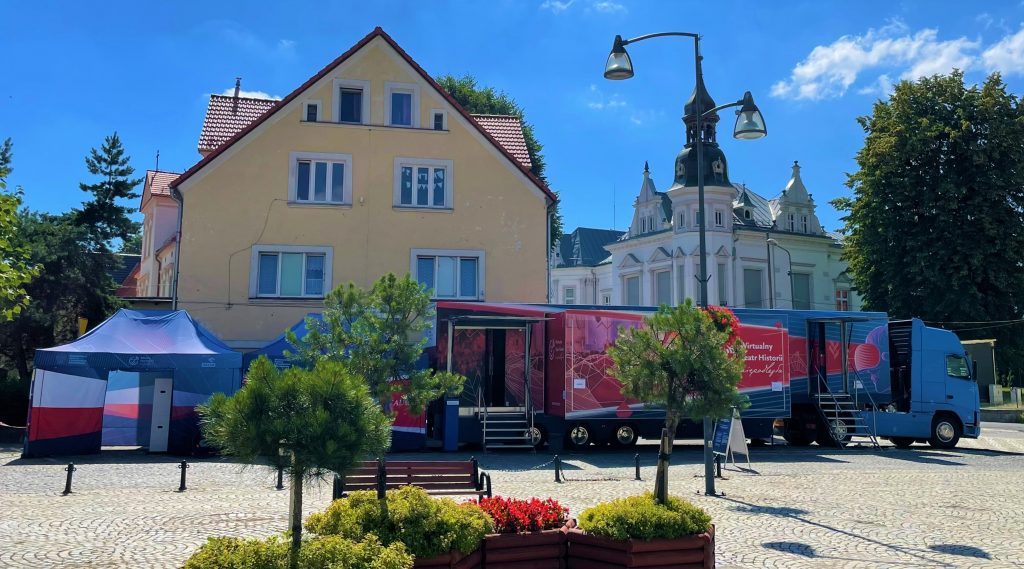 samochód Wirtualnego Teatru Historii na tle budynków