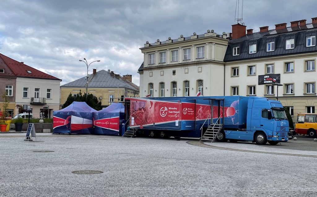 samochód Wirtualnego Teatru Historii na tle zabudowy rynku