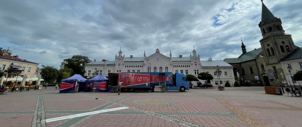 samochód Wirtualnego Teatru Historii na tle zabudowy rynku