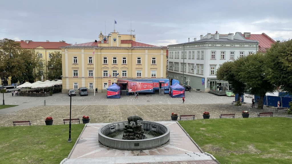 samochód Wirtualnego Teatru Historii na tle zabudowy rynku