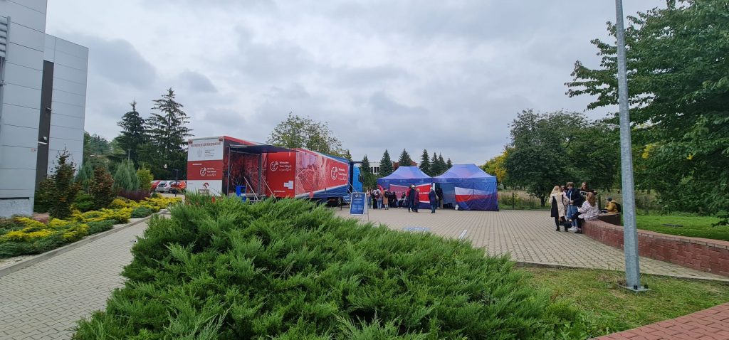samochód Wirtualnego Teatru Historii na tle budynku