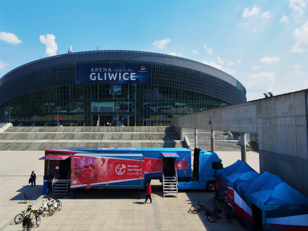 samochód Wirtualnego Teatru Historii w Działoszynie, w tle Arena Gliwice