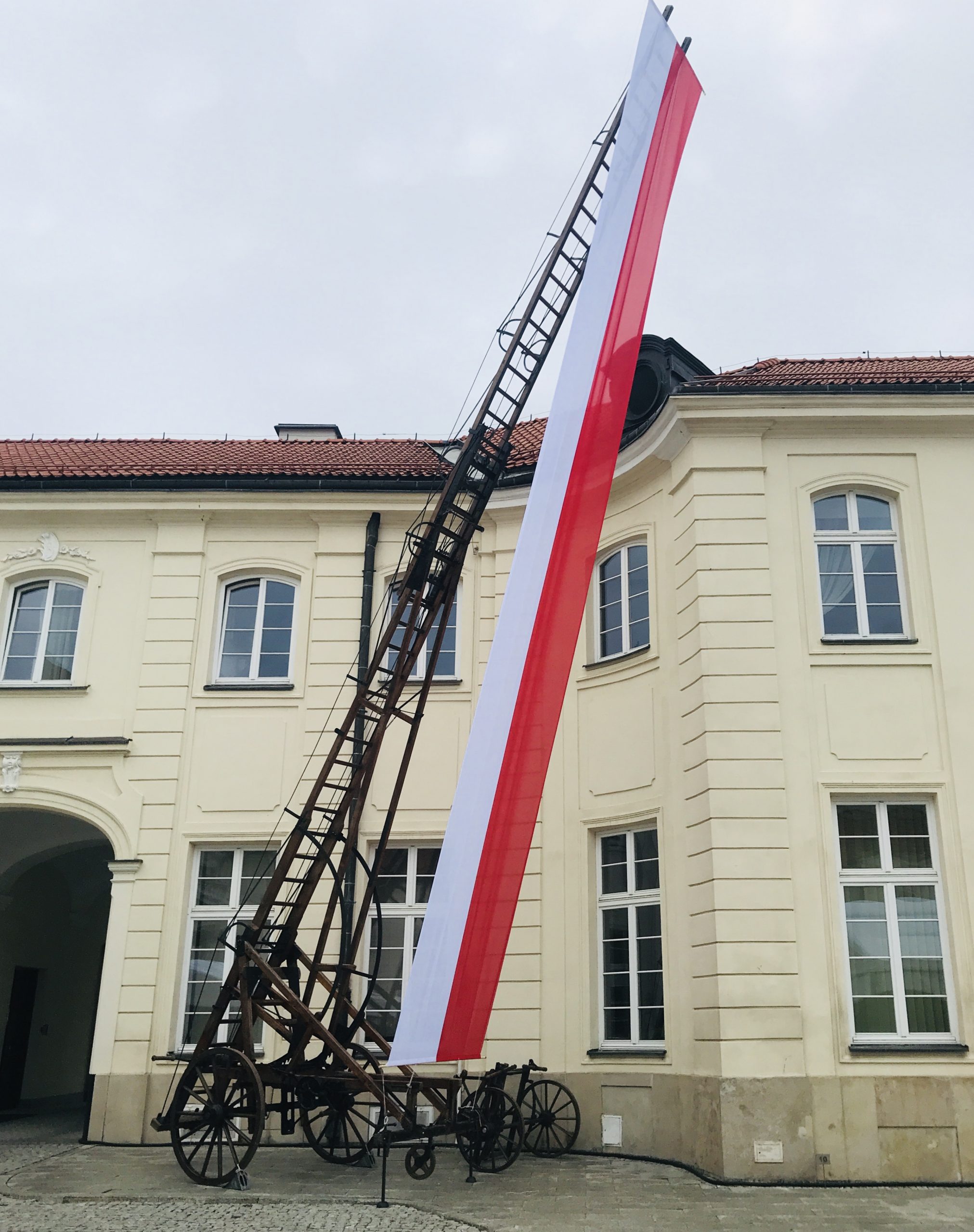 drabina strażacka z rozwiniętą flagą Polski