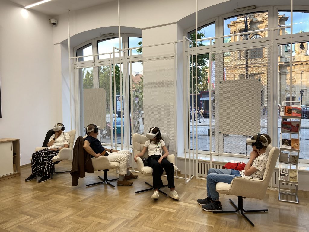 wnętrze sali z fotelami VR, za oknami ulica Krakowskie Przedmieście