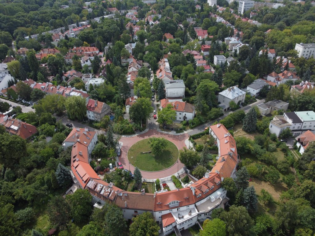 widok z lotu ptaka na półokrągły budynek i odchodzące od niego ulice z zabudową rezydencjonalną