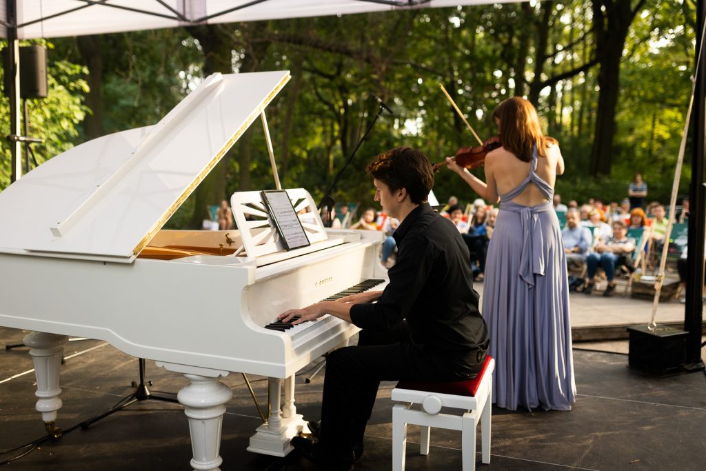 na scenie mężczyzna przy fortepianie i skrzypaczna