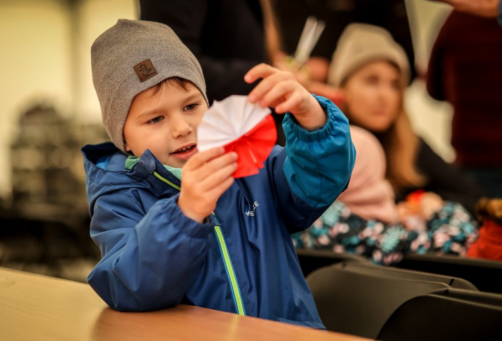 chłopczyk z biało-czerwoną ozdobą którą wykonał