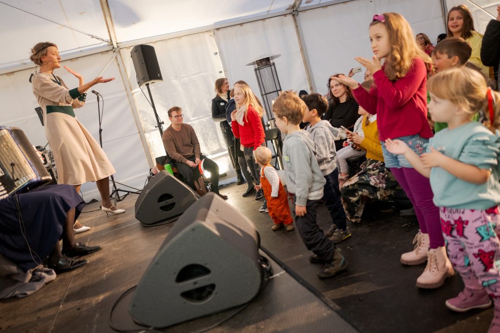 aktorka ze sceny i klaszczące dzieci na widowni