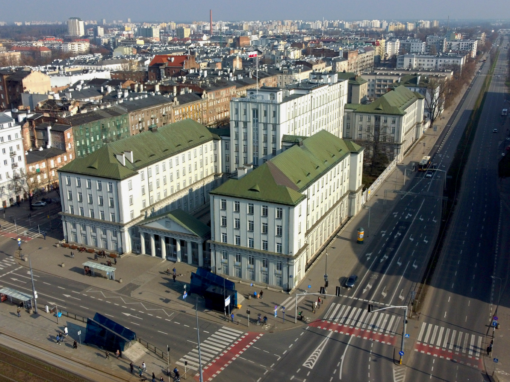 budynek Dyrekcji Okręgowej Kolei Państwowych w warszawie z lotu ptaka, w tle panorama prawobrzeżnej warszawy
