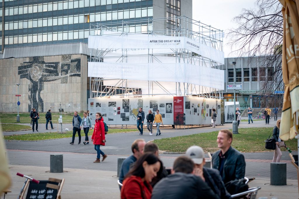 biało-srebrny pawilon z wystawą w kształcie sześcianu w przestrzeni miejskiej