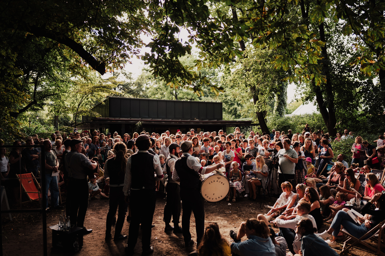 zdjęcie z koncertu na świeżym powietrzy, przedstawia orkiestrę i tłum słuchaczy